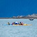 People in a kayak watching a whale raise its tail out of the water